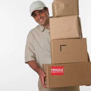 Studio shot of deliveryman holding stack of boxes Stockfoto's