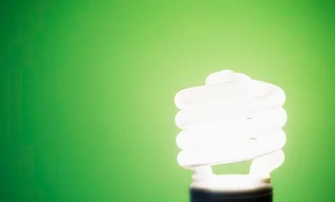Studio shot of energy efficient lightbulb on green background Stock Photos