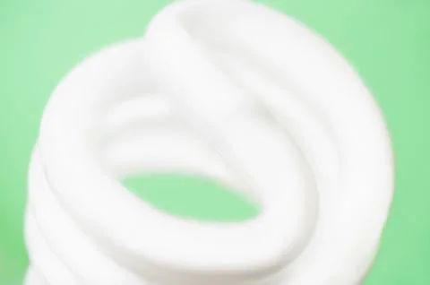 Studio shot of energy efficient lightbulb on green background Stock Photos