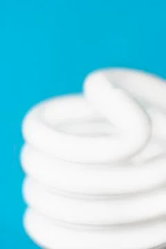 Studio shot of energy efficient lightbulb on blue background Stock Photos