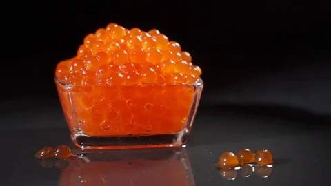 Studio shot of female hand taking red caviar with spoon out of glass jar Stock Footage 124119735