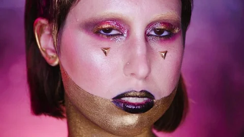 Studio Shot of a Golden Glittery Body Woman. Purple Background. Stock Footage