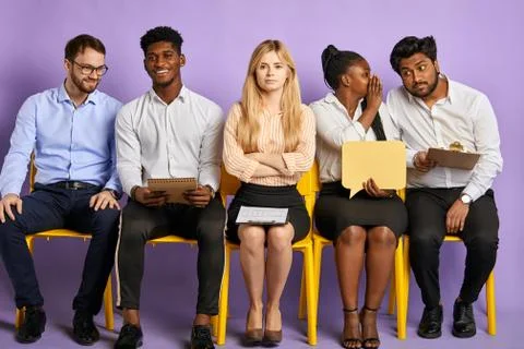 Studio shot of group of multicultural people sitting on chairs Stock Photos