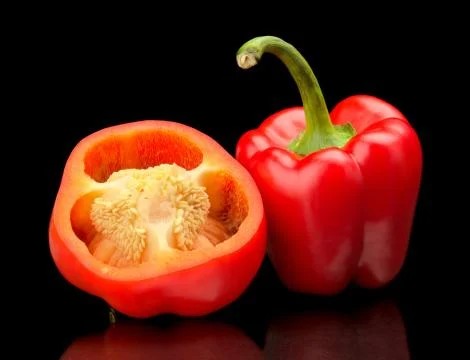 Studio shot of halved red bell peppers isolated on black background Stock Photos
