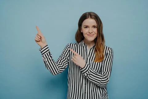 Studio shot of happy female pointing up at copy space Stock Photos