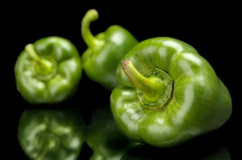 Studio shot macro view of green bell peppers in the corner isolated on black Stock Photos
