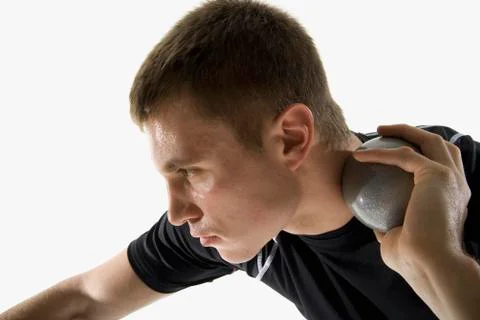 Studio shot of a male track and field athlete holding a shot put ball Stock Photos