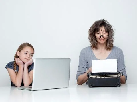 Studio shot of mother using typewriter and daughter (10-11) looking at laptop Foto stock