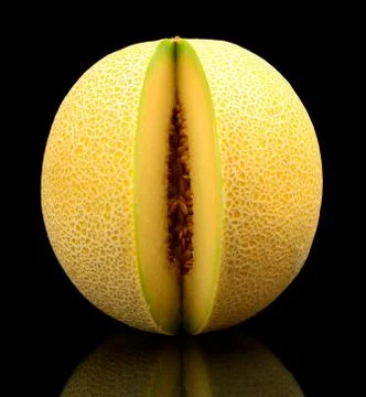 Studio shot of notched ripe melon galia isolated on black background Stock Photos