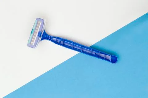 Studio shot of plastic blue razor on split blue and white background Stock Photos