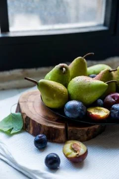 Studio shot plums and pears on plate heathy diet Stock Photos