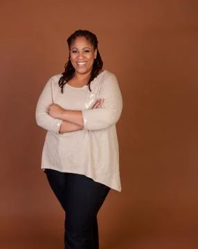 Studio shot of a plus size black woman in a beige top Stock Photos