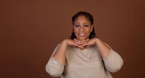 Studio shot of a plus size black woman in a beige top Stock Photos