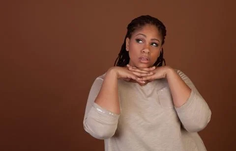 Studio shot of a plus size black woman in a beige top Stock Photos