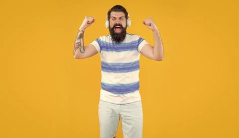 Studio shot of shouting hipster guy with earphones. listening to music. modern Stock Photos