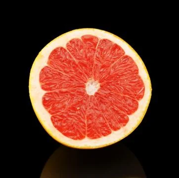 Studio shot of sliced grapefruit in half isolated on black background Stock Photos