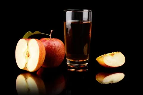Studio shot of sliced red apple with leaf and apple juice isolated on a black Stock Photos