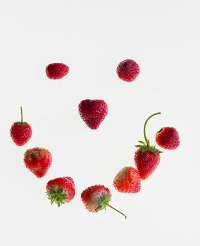 A studio shot of a smiley face made out of strawberries isolated on a white Stock Photos