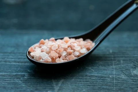 Studio shot of spoon with rough pink salt Stock Photos