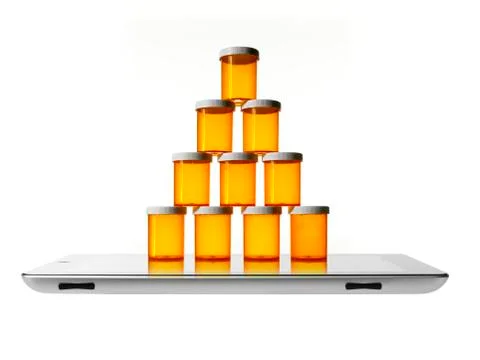 Studio shot of stack of pill bottles on digital tablet 写真素材