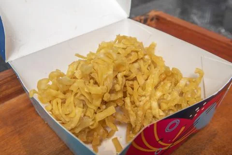 Studio shot of three crispy fried dumplings inside an open paper box restin.. Фото