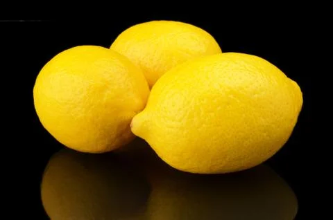 Studio shot of three lemons isolated on black background Stock Photos