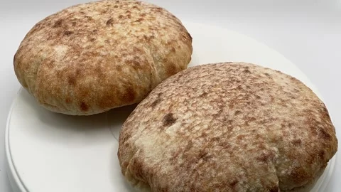 Studio shot of two pita bread loaves rotating on white background. Stock Footage 340450702