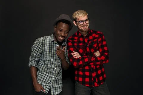 Studio shot of two stylish young men having fun. Handsome bearded hipster in a Stock Photos