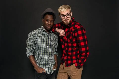 Studio shot of two stylish young men having fun. Handsome bearded hipster in a Stock Photos