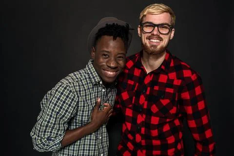 Studio shot of two stylish young men having fun. Handsome bearded hipster in a Stock Photos
