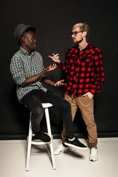 Studio shot of two stylish young men having fun. Handsome bearded hipster in a Stock Photos