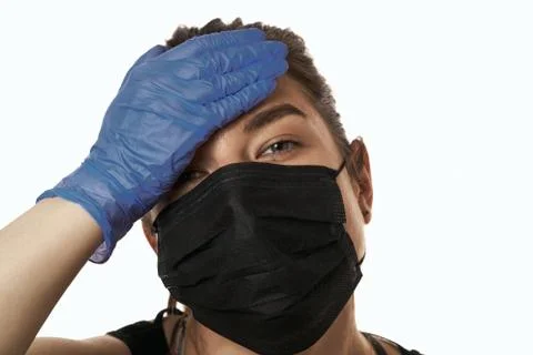 Studio shot on white background of a sick young woman wearing mask and latex  스톡 사진