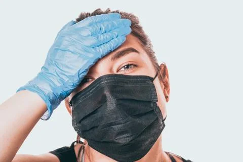 Studio shot on white background of a sick young woman wearing mask and latex  库存照片