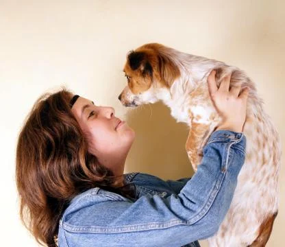 Studio shot of a young lady holding a little dog Stock Photos