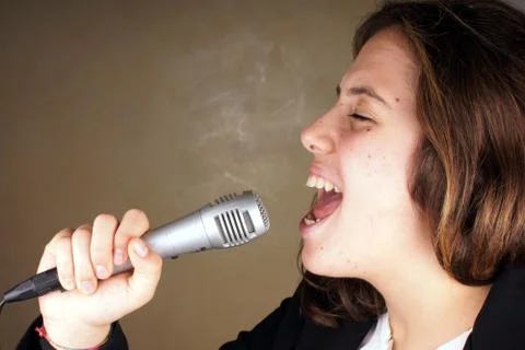 Studio shot of a young lady with microphone Stock Photos