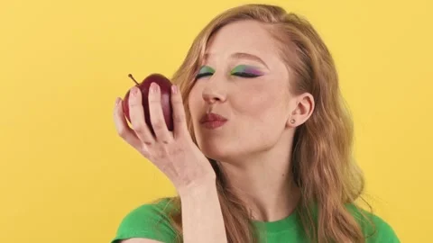 Studio shot of a young red-haired woman who stands on a yellow background and Stock Footage 241337611