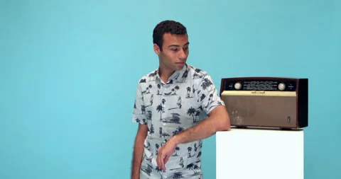 Studio, slow motion, young man listens to a vintage radio Stock Footage 140436648