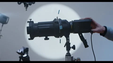 Studio spotlight projector with technician adjusting beam Stock Footage 328660147