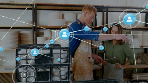 Studio team pointing at clipboard starting blue net growing from node across 動画素材 332544686