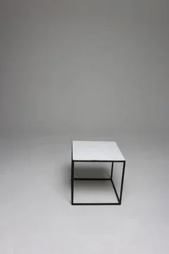 Studio white chair in the shape of a cube on a gray background. Stock Photos