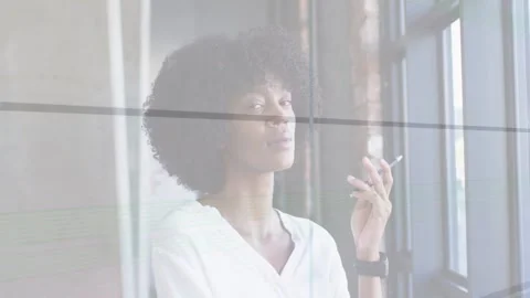 Studio woman standing by pane window with glass lines, raising slim device, Stock Footage 333594472