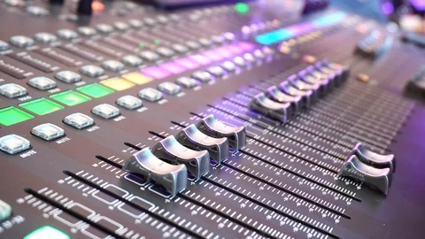 The studios audio mixer board console and a hand pulling up the knobs. Select Stock Footage 86324984