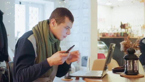 Studious man working. Concentrated person multitasking at cozy cafe table. Quiet Stock Footage 338985036