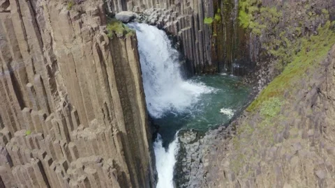 Studlabergsfoss waterfall narrow and long cascade around hexagonal basalt column Stock Footage 138738828