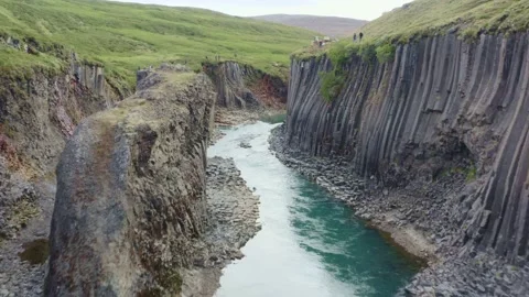 Studlagil canyon with basalt columns contrast between blue river and orange tone Stock Footage 138739907