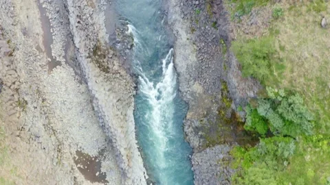 Studlagil canyon with basalt columns wall contrast with blue turquoise river Stock Footage 138739636