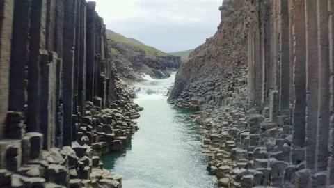 Studlagil canyon with hexagonal basalt columns contrast with blue orange tone Stock Footage 138739599