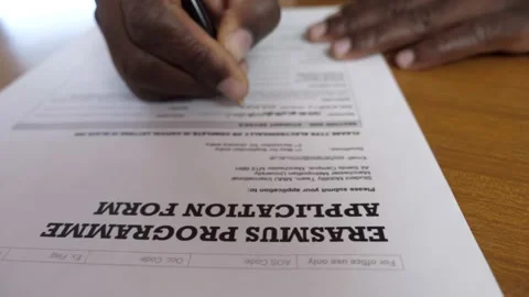 Study abroad-hand of black guy writes data on the form for the Erasmus programme 스톡 동영상 231681630
