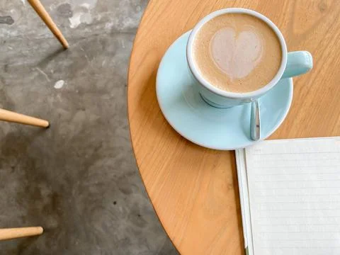 Study and work at the cafe. a cup coffee with an open book on the wooden table Stock Photos