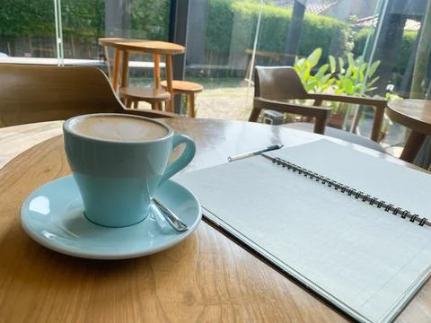 Study and work at the cafe. a cup coffee with an open book on the wooden table Stock Photos